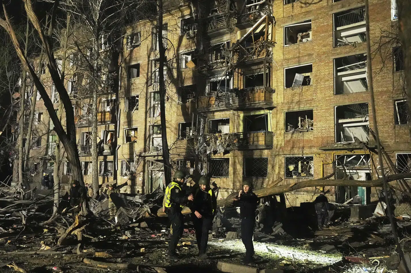 Ukrainsk politi og redningsmandskab arbejder ved en beboelsesejendom i Ukraines hovedstad, Kyiv, hvor et russisk missilangreb natten til torsdag har dræbt mindst 12 mennesker og såret over 90 andre.