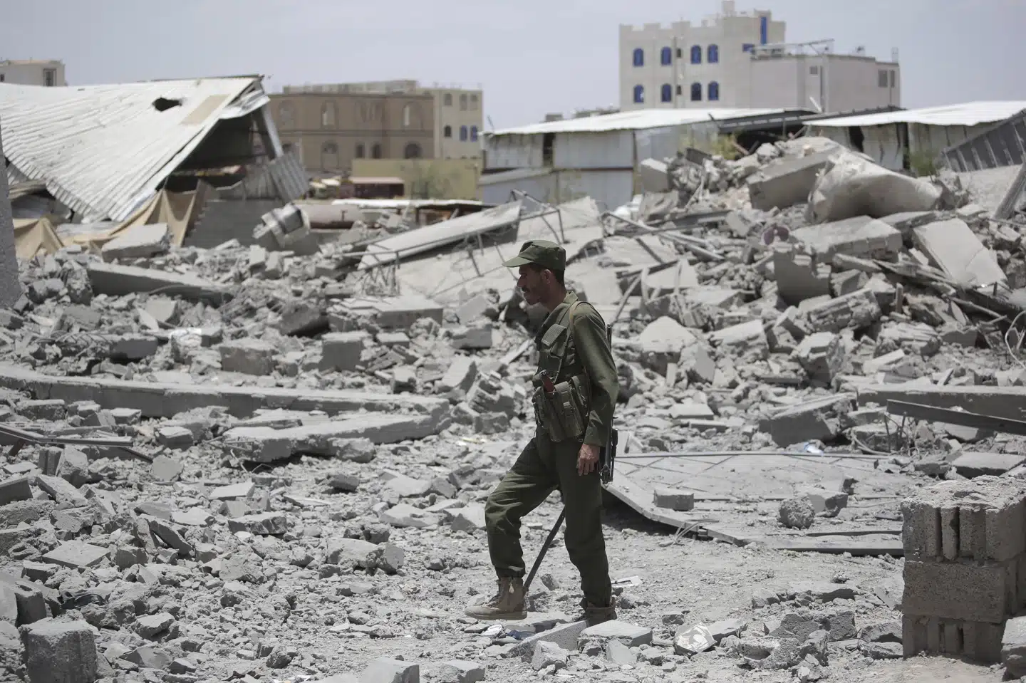 En yemenitisk officer ses søndag gennemse murbrokkerne fra en bygning, som er blevet ødelagt af amerikanske luftangreb.