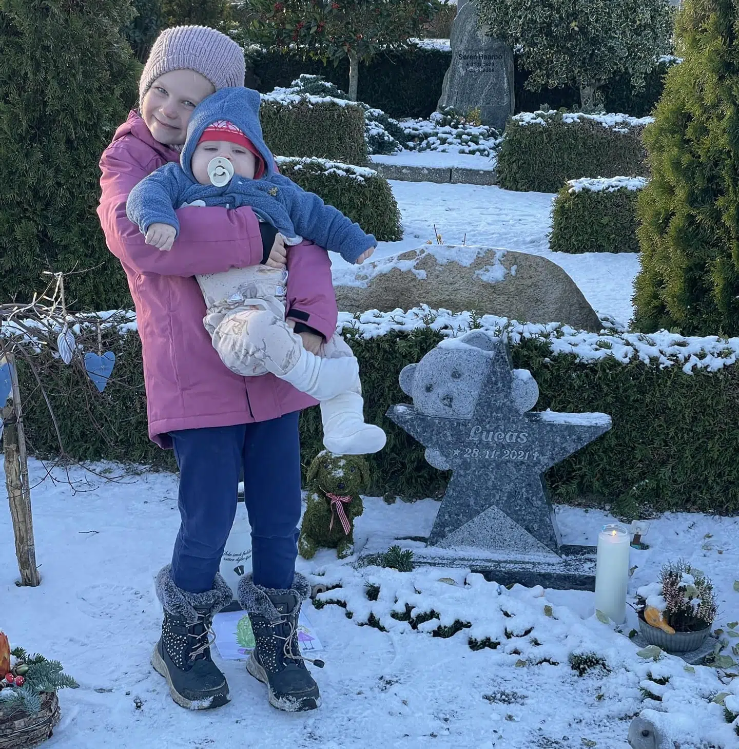 Lucas' storesøster og lillebror ved hans gravsted sidste vinter på toårsdagen for hans død.