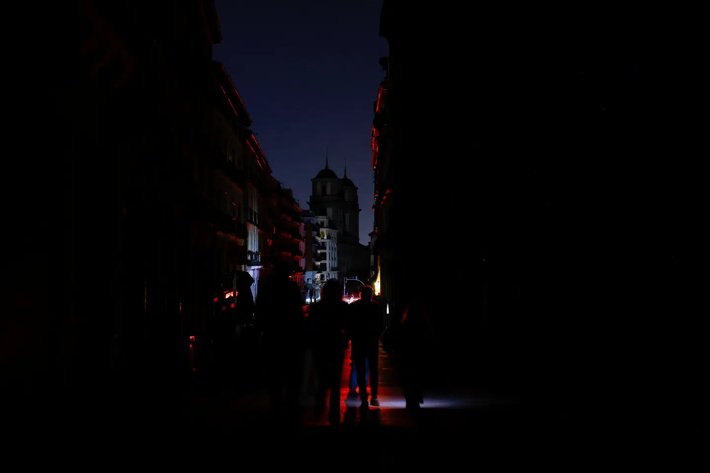 Her ses folk bruge lommelygter, mens de går i mørket i Madrid den 28. april.
