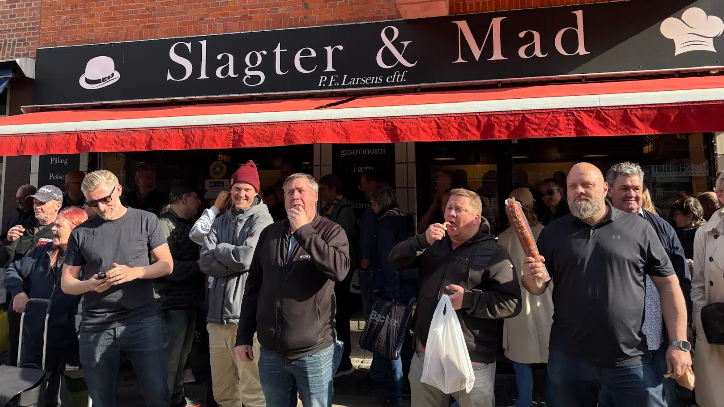 Kunder står og spiser kød foran Slagter & Mad.