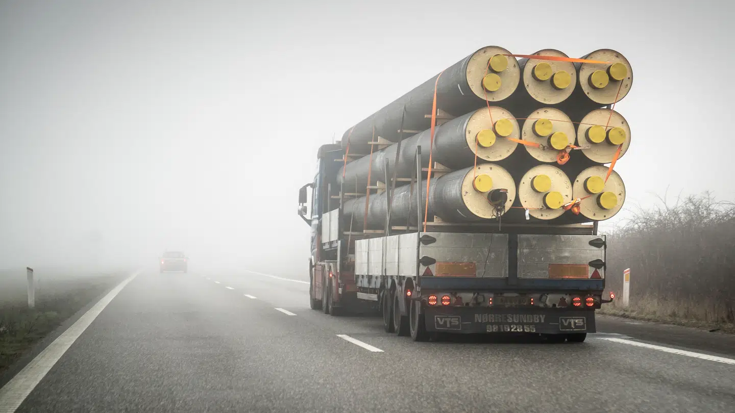 En lastbil transporterer fjernvarmerør.