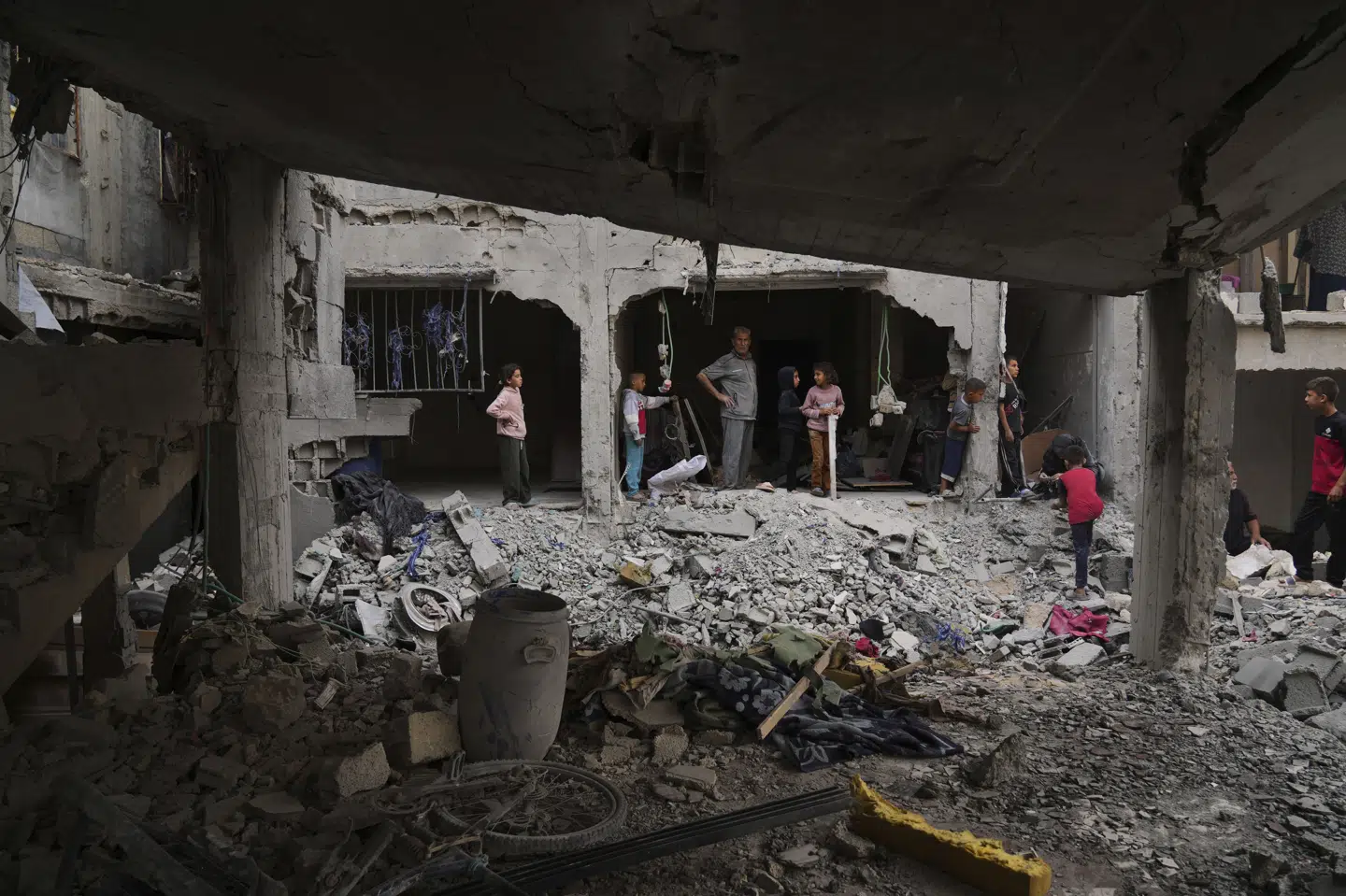 En familie kigger på ruinerne af deres hjem, der er blevet ødelagt efter et israelsk angreb i byen Khan Younis i det sydlige Gaza torsdag.