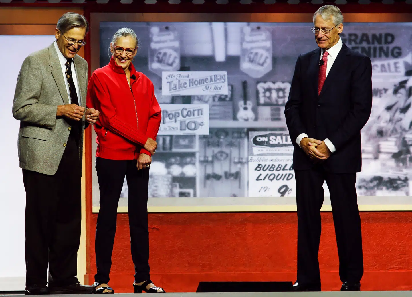 Her ses Alice Walton sammen med sine brødre Jim Walton (tv) og Rob Walton (th) ved Walmarts årlige aktionærmøde i Fayetteville, Arkansas i 2012.