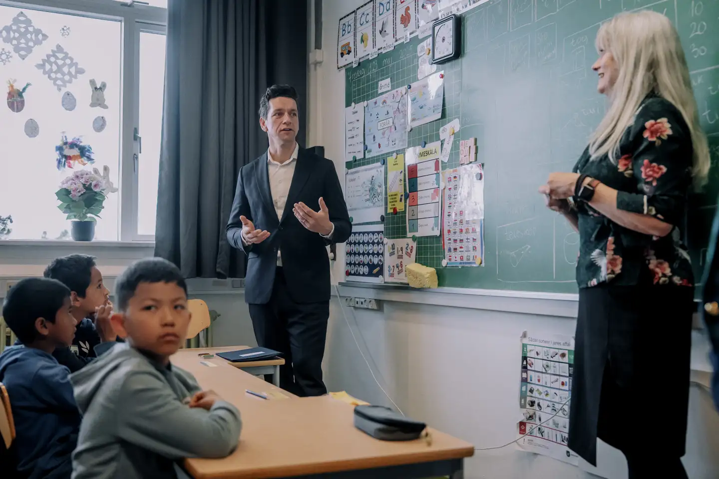 Dansklærer på Brøndbyvester Skole i Brøndby Mette Ishøy forklarer udlændinge- og integrationsminister Kaare Dybvad (S), hvordan hun ikke bare er lærer for børnene i modtageklassen M2A, men også en form for velkomstkomité til det danske samfund for deres familier.