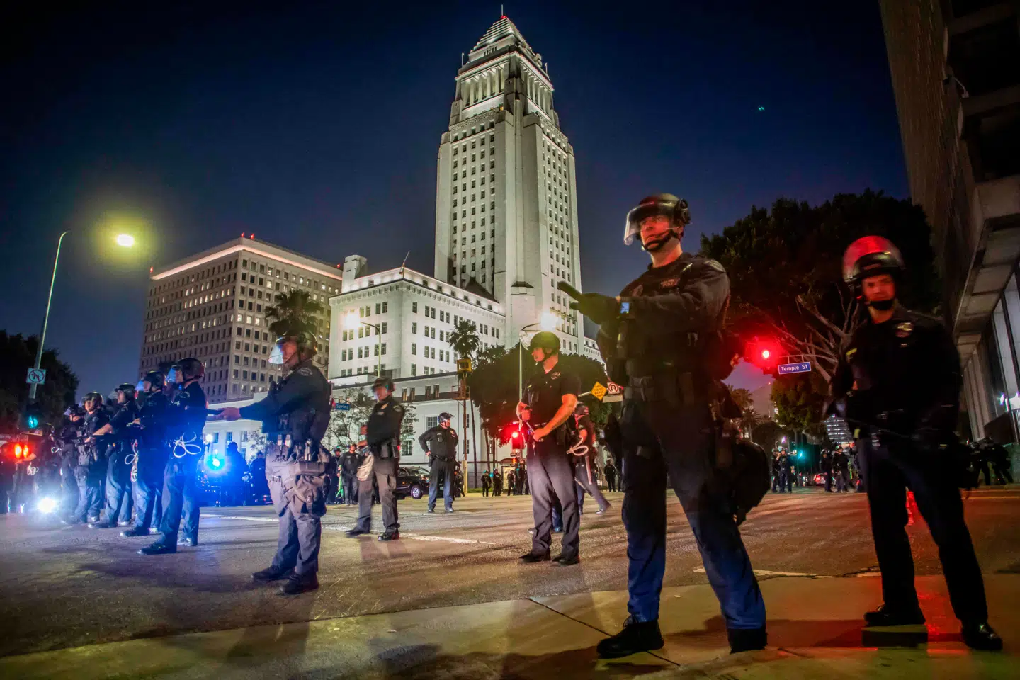 Los Angeles´ politi står foran byens rådhus, efter at et udgangsforbud er trådt i kraft. Der var anholdelser, fordi folk trodsede udgangsforbuddet for at protestere mod de føderale myndigheders jagt på illegale indvandrere. (Foto Apu GOMES / AFP)