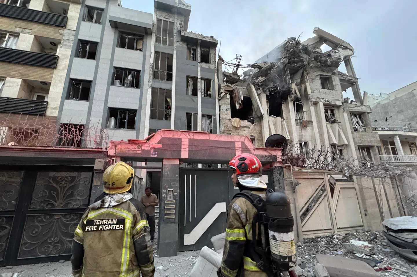 Brandfolk besigtiger en ødelagt bygning i Teheran efter nattens angreb.