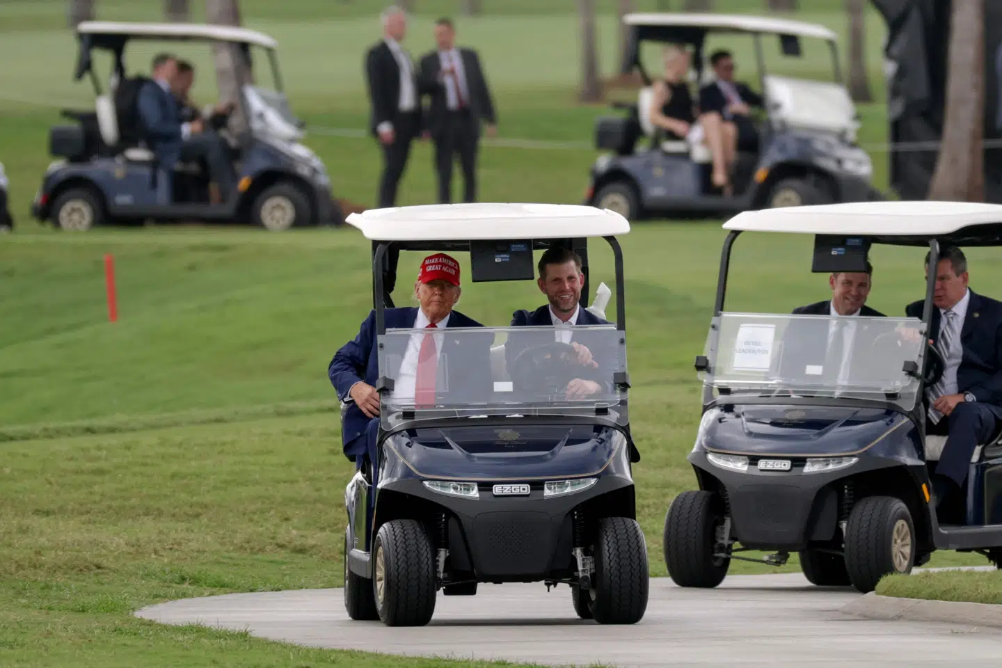 Donald Trump og sønnen Eric Trump kører gennem Trump National Doral Golf Club. Donald Trump ejer flere golfbaner. (Arkivfoto).