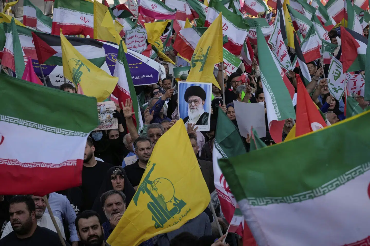 Demonstranter i Irans hovedstad, Teheran, holder et billede af landets øverste leder, ayatollah Ali Khamenei, under en demonstration lørdag i forbindelse med en shiamuslimsk helligdag. Dagen inden havde Israel indledt sin militære operation mod mål i Iran. Ud over det iranske flag bærer demonstranterne også det gule flag fra den libanesiske milits Hizbollah, der er nær allieret med det iranske styre.