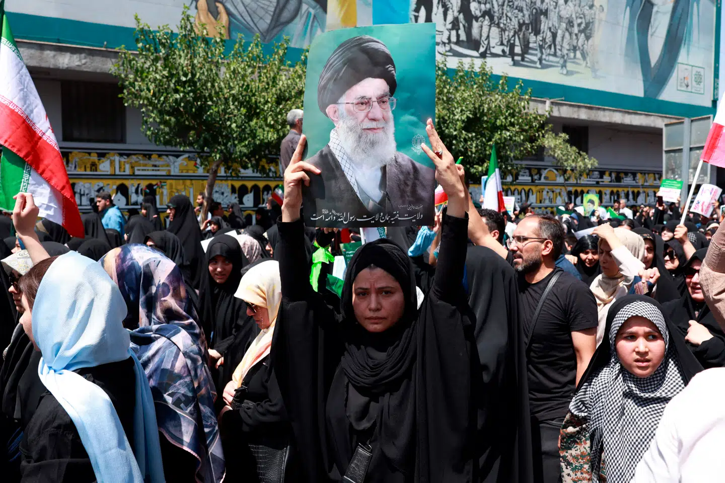 En kvinde bærer et foto af Irans øverste åndelige leder, Ali Khamenei, under antiisraelske demonstrationer i Teheran fredag.