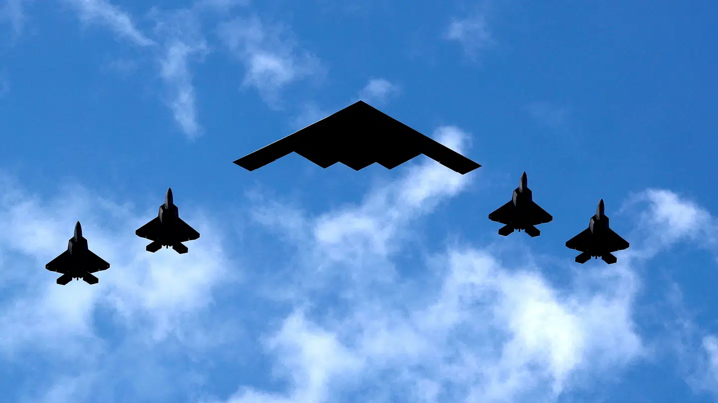 Et B-2 Spirit-bombefly flankeret af fire F-35 jetjagere.