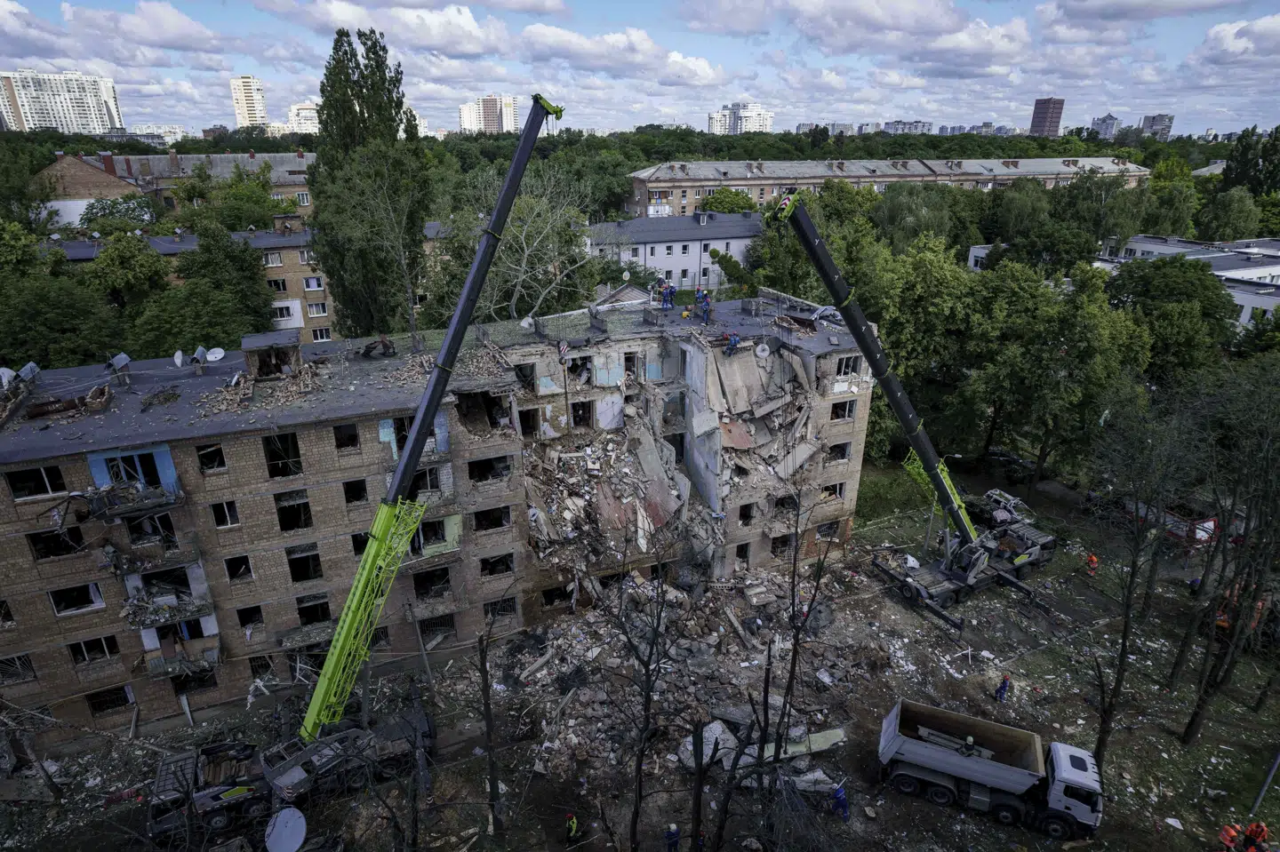 Redningsarbejdere forsøger at fjerne murbrokker ved ødelagt bygning efter russisk angreb mandag.