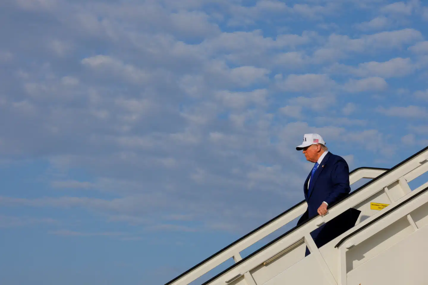 Donald Trump iførte sig en hvid kasket med »USA«-tryk på, idet han gik ud ad døren fra flyet.
