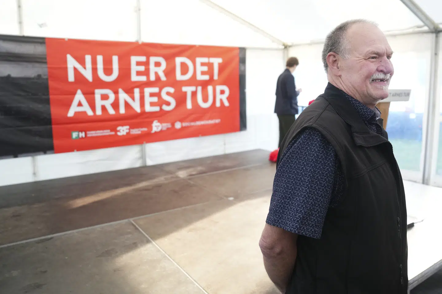 Tidligere bryggeriarbejder Arne Juhl står her foran et socialdemokratisk banner ved et 1. maj-arrangement i 2024. I 2019 blev Arne Juhl billedet på Socialdemokratiets valgløfte om en værdig tilbagetrækning for de mest nedslidte, der siden blev kendt som Arne-pensionen. (Arkivfoto).