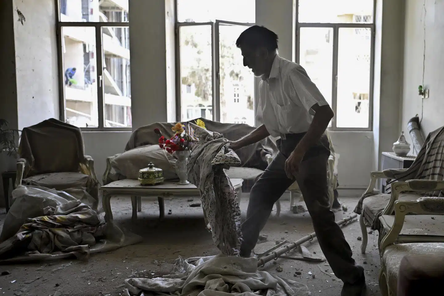 En mand gør rent i en lejlighed i den iranske hovedstad, Teheran, efter at lejligheden er blevet beskadiget i et missilangreb.