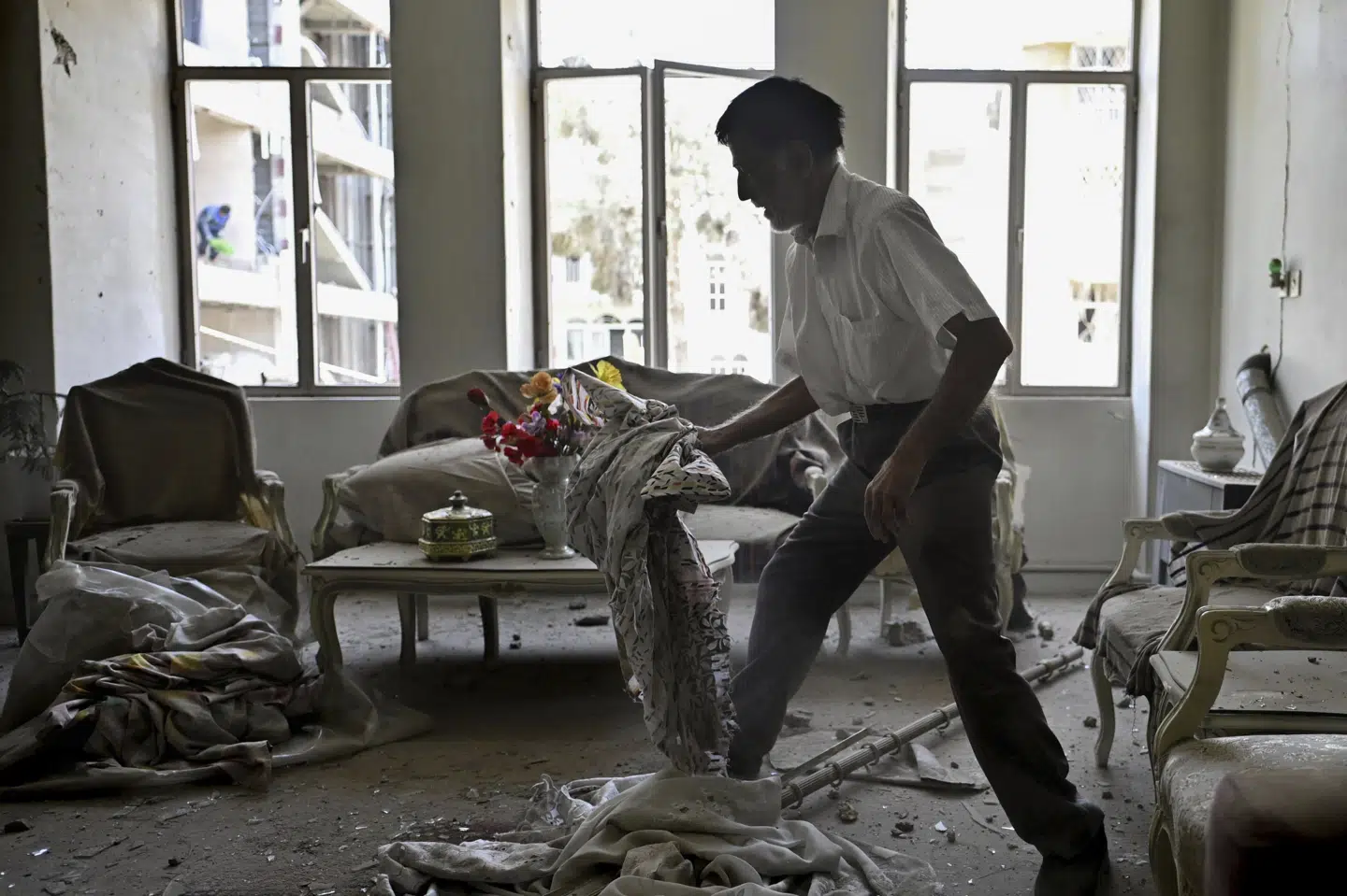 En mand gør rent i en lejlighed i den iranske hovedstad, Teheran, efter at lejligheden er blevet beskadiget i et missilangreb.