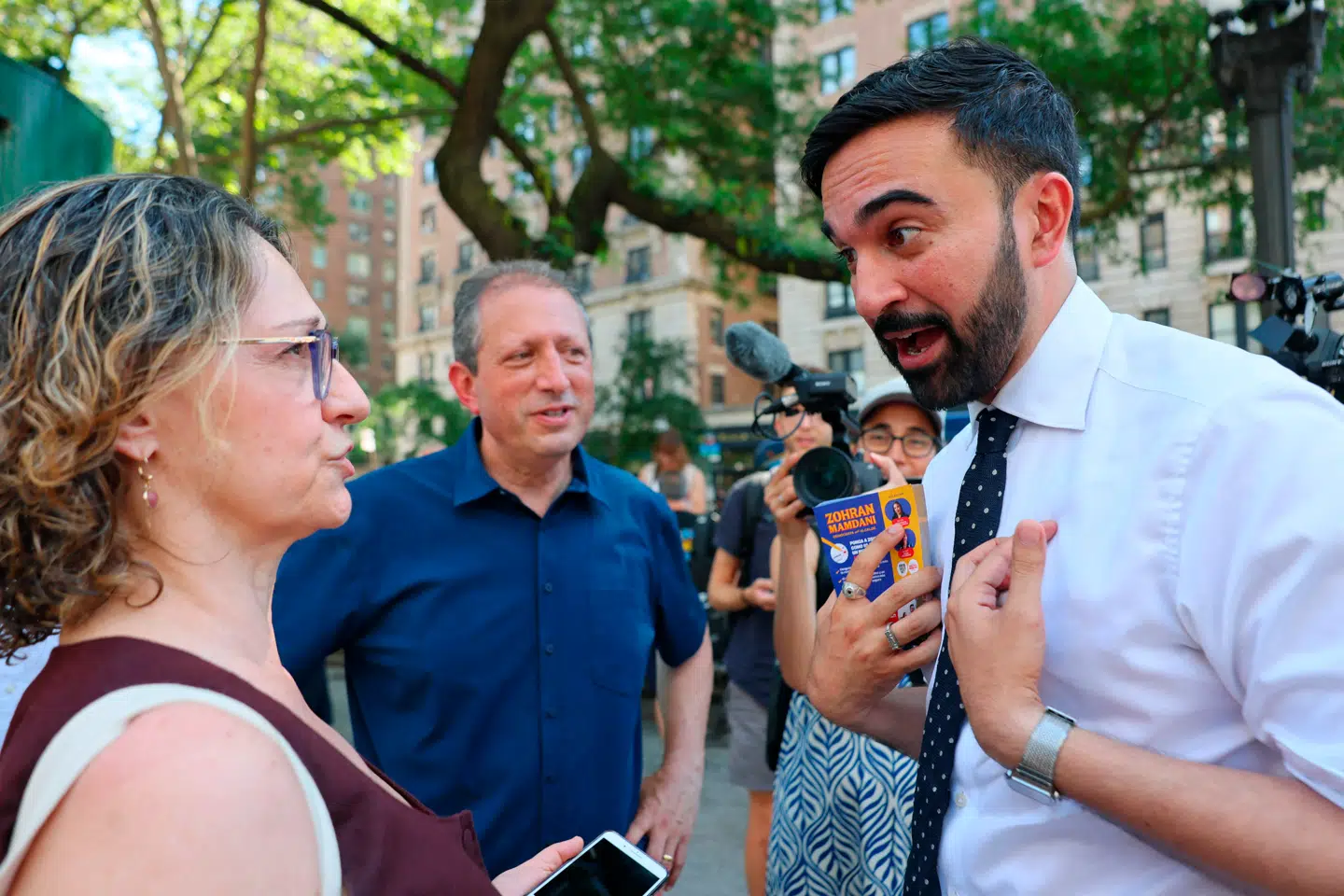 Zohran Mamdani har vundet en overraskende sejr og er nu Demokraternes kandidat til borgmesterposten i New York. Den 33-årige politiker med muslimsk baggrund hører til partiets venstrefløj, men det er i mindre grad hans socialistiske ideer end hans manglende afstandtagen til et problematisk slogan, der udløser bekymring i det amerikanske tidsskrift The Atlantic. På billedet møder Mamdani (th.) lokale vælgere i New York 24. juni 2025.