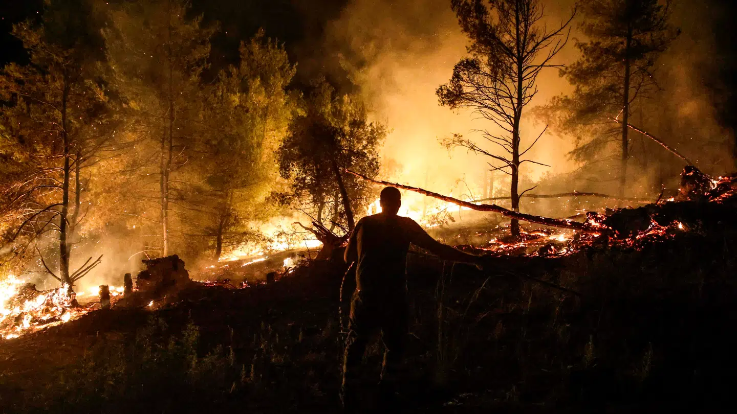 En frivillig brandmand hjælper med at bekæmpe en brand på øen Evia i Grækenland.