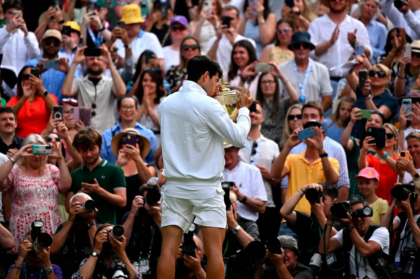 Spanske Carlos Alcaraz kysser trofæet foran publikum og fotografer efter sejren mod serbiske Novak Djokovic ved Wimbledon i 2024. Foto: Andrej Isakovic, Scanpix