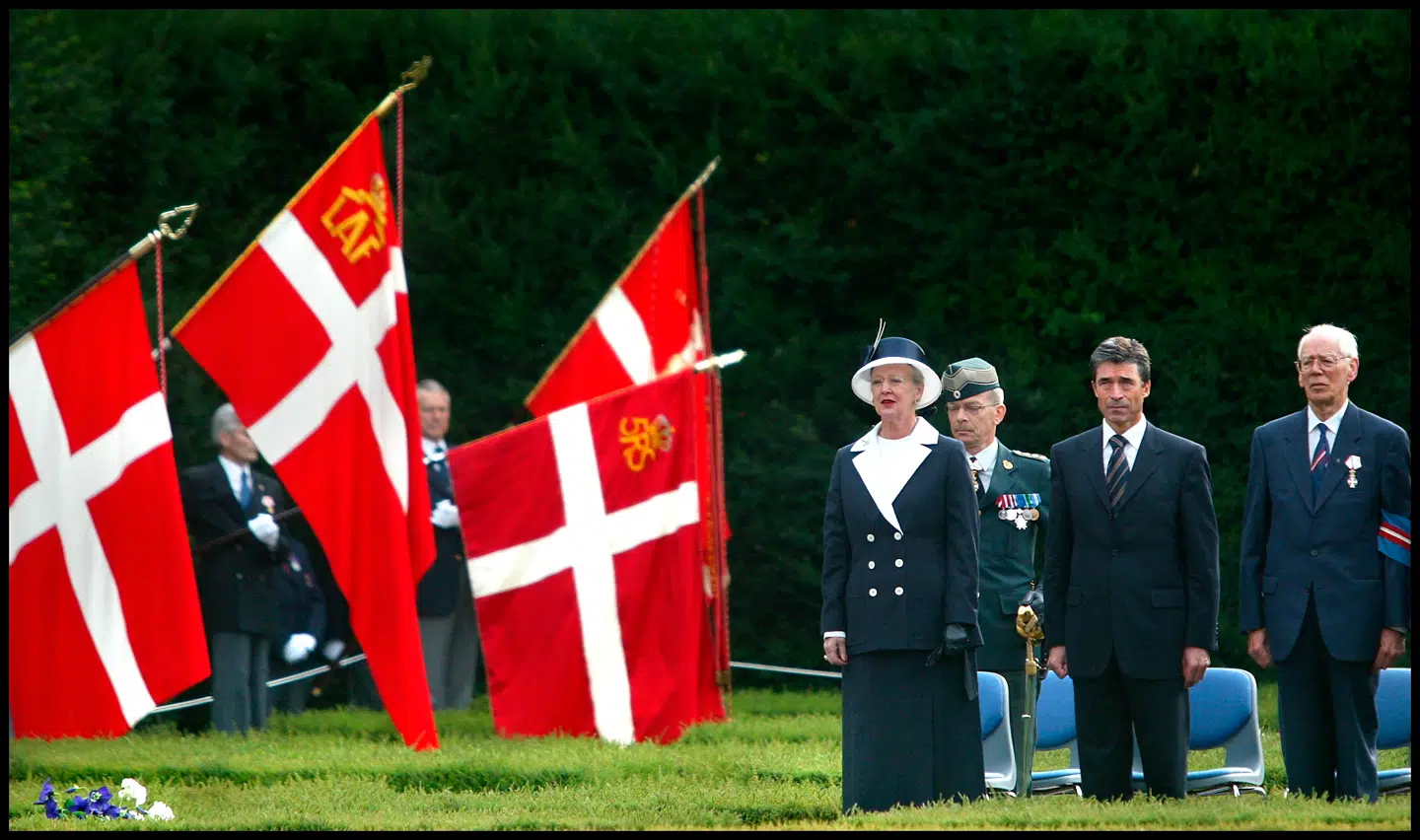 Anders Fogh Rasmussen holdt 29. august 2003 en af sine mest opsigtsvækkende taler som statsminister. På 60-års-dagen for det officielle brud med samarbejdspolitikken gik han i en tale på Søværnets Officersskole til angreb på den danske samarbejdspolitik under besættelsen. Nu fortæller han om kilderne til sin tale og river dermed tæppet væk under en af præmisserne i en historikerstrid. Billedet her er taget 29. august 2003 i Mindelunden og viser dronning Margrethe og Anders Fogh Rasmussen ved mindehøjtideligheden.