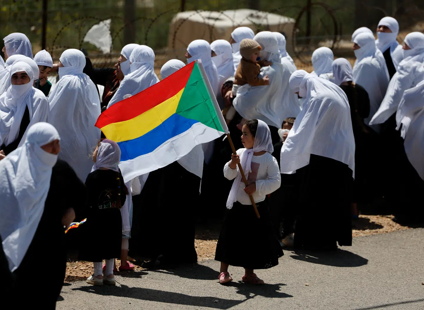 En pige bærer drusernes flag, mens israelske drusere venter på at hilse på syriske drusere ved grænsen mellem Syrien og de israelsk besatte Golanhøjder ved den årlige sammenkomst ved Nabi Shuayb-helligdommen, der er et helligt sted for det drusiske samfund.