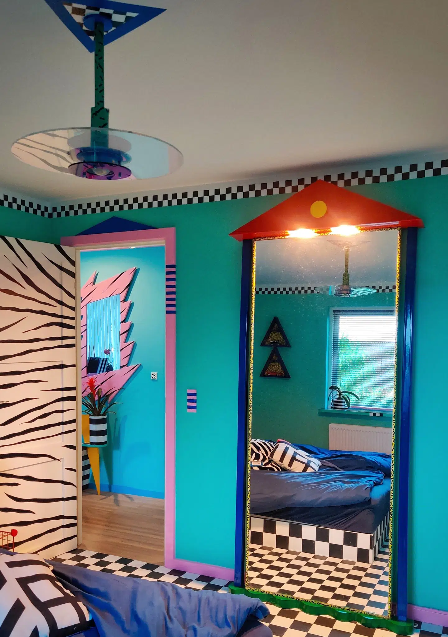 En stor del af gulvet i hjemmet er også beklædt med vinyl. I soveværelset har han valgt en ternet variant, der i samspil med de turkise vægge og lyserøde paneler giver 'amerikansk diner'-vibes.