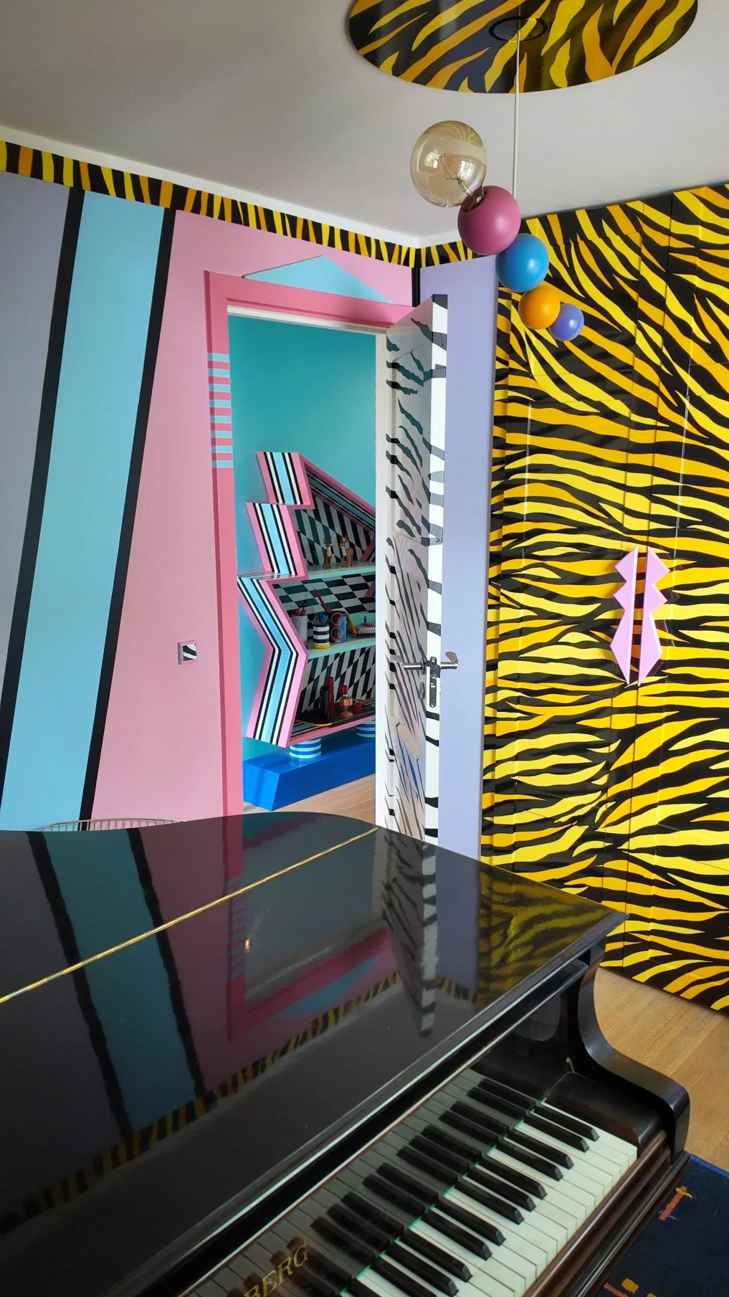 Væggene er malet i forskellige farver, mens det indbyggede skab er beklædt med zebra-vinyl – her i en gul og sort variant.