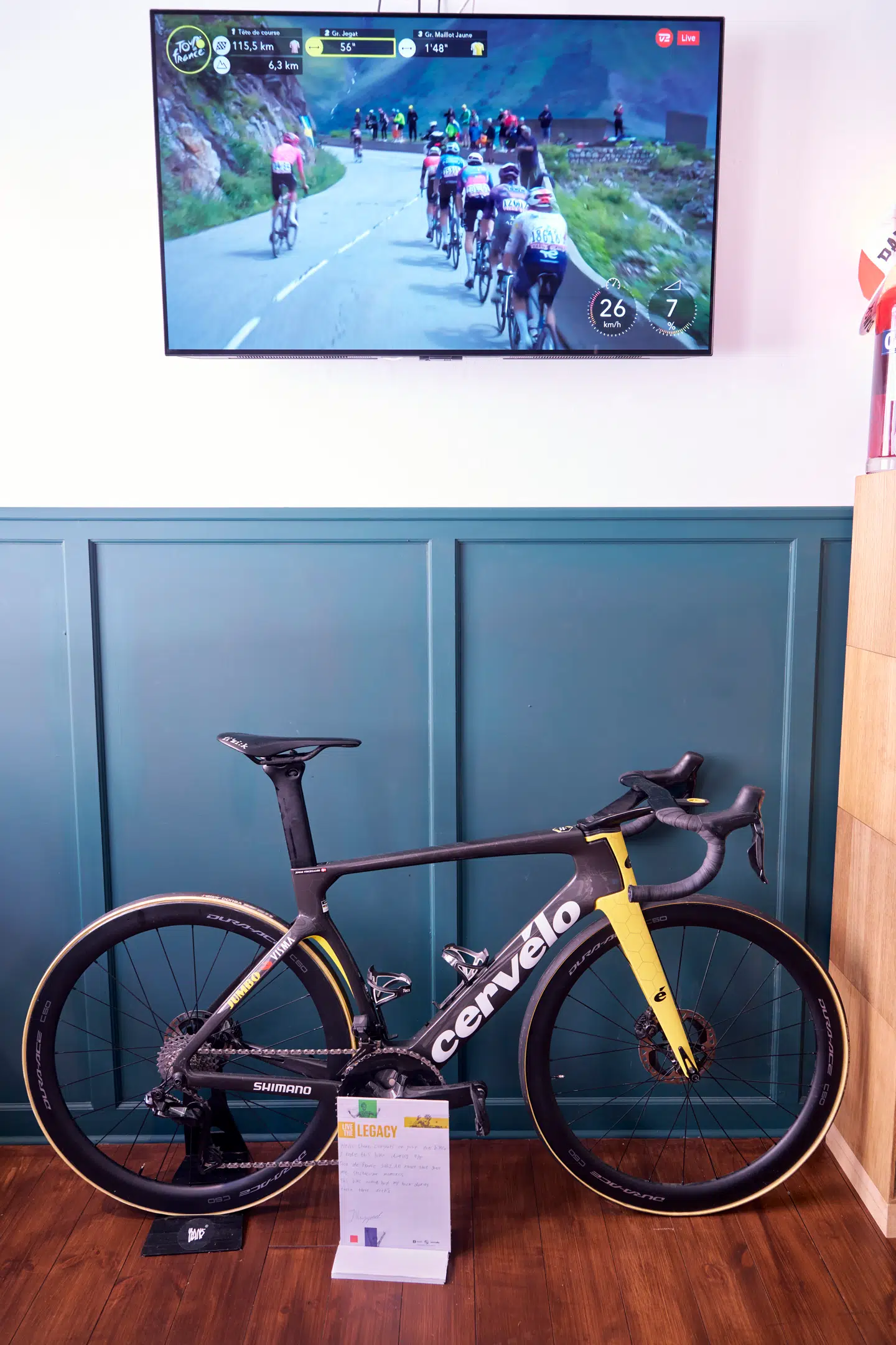 Jonas Vingegaards enkeltstartscykel. I baggrunden vises der Tour de France 2025.