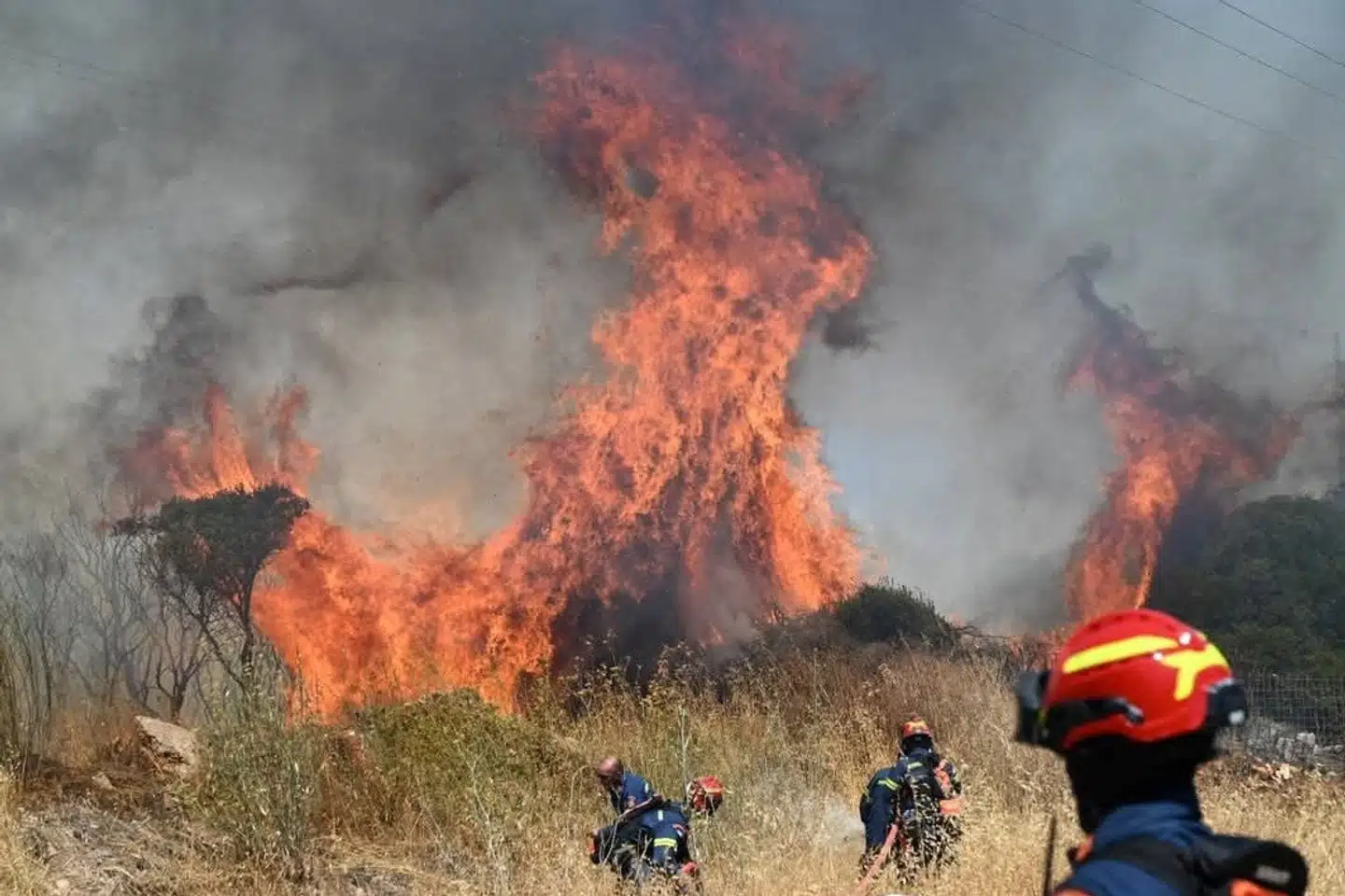 Brandfolk er her i færd med at kvæle flammerne i en skovbrand på den græske ø Kythira lørdag. (Arkivfoto).