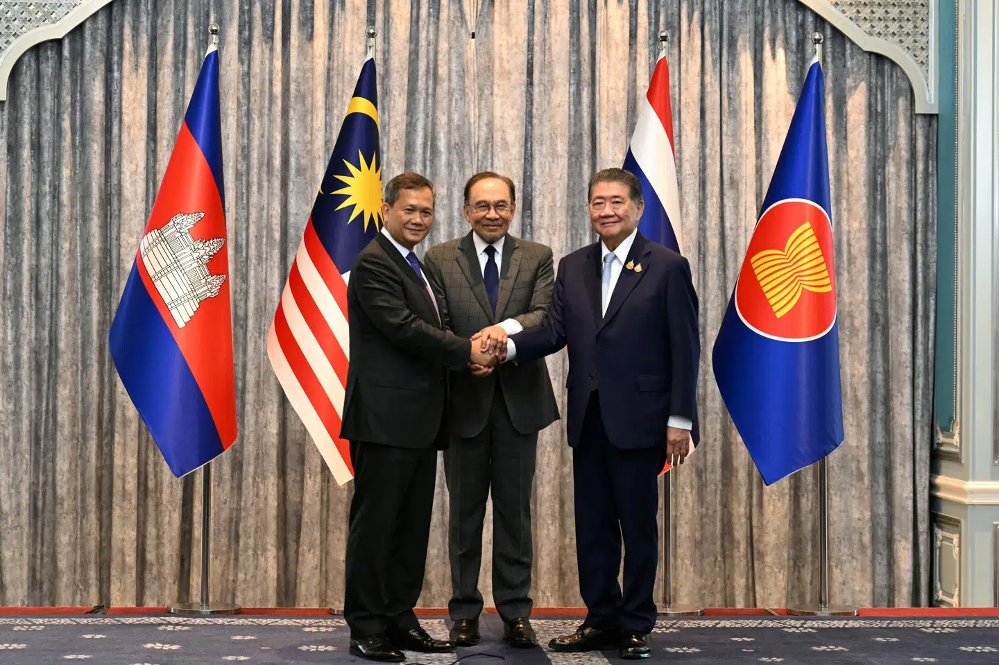 Cambodjas premierminister, Hun Manet,  sammen med Malaysias premierminister, Anwar Ibrahim, og Thailands fungerende premierminister, Phumtham Wechayachai, efter forhandlinger om våbenhvile mandag den 28. juli.  Anwar Ibrahim fungerede som mægler under forhandlingerne.