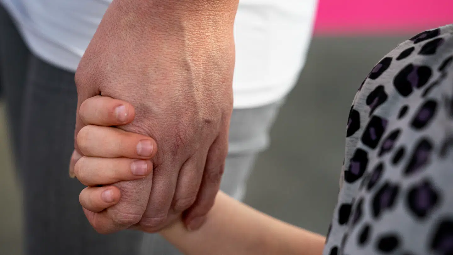 Arkivfoto af en voksen og et barn, der holder i hånden.