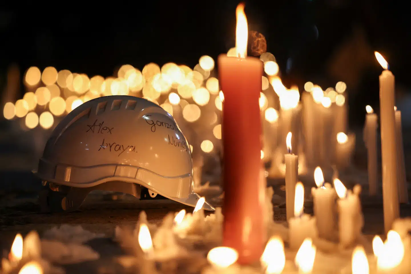 Foran det statsejede chilenske mineselskab Codelco er der blevet placeret en hjelm, hvor navnene på minearbejdere, der torsdag blev fanget efter en sammenstyrtning i en kobbermine, er skrevet på.