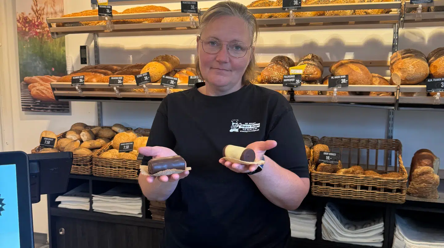 Her ses bageren Signe Duvander stå bag skranken med to træstrammer i hånden.