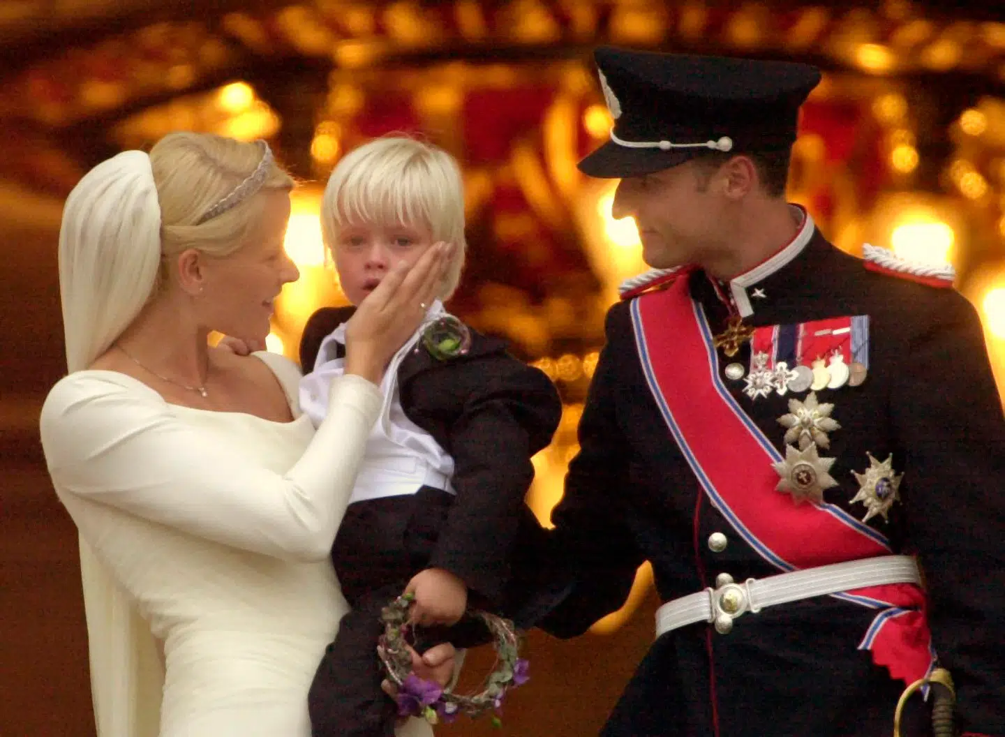 Norges kronprins Haakon og kronprinsesse Mette-Marit med hendes søn, 4-årige Marius, på kongeslottets balkon. Mange nordmænd var i 2001 mødt op på slotspladsen for at hylde det nygifte par.