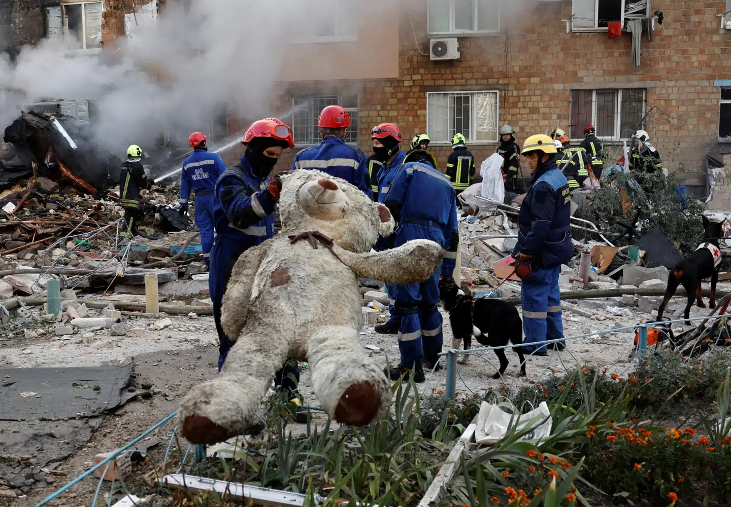 En redningsmand holde en bamse ved en bygning, der blev ramt af russiske missiler og droner i Kyiv, Ukraine 28. august.