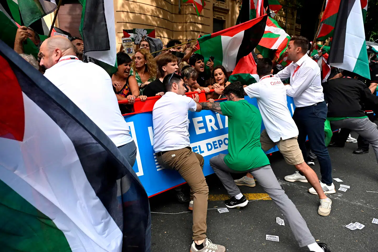 Løbsansvarlige forsøger at holde propalæstinensiske demonstranter tilbage ved målstregen til Vueltaens 11. etape.