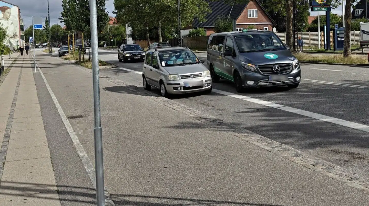 På billede kan man se el-delebilsparkeringszonen. I ruden på den grå bil, kan man se en p-bøde.