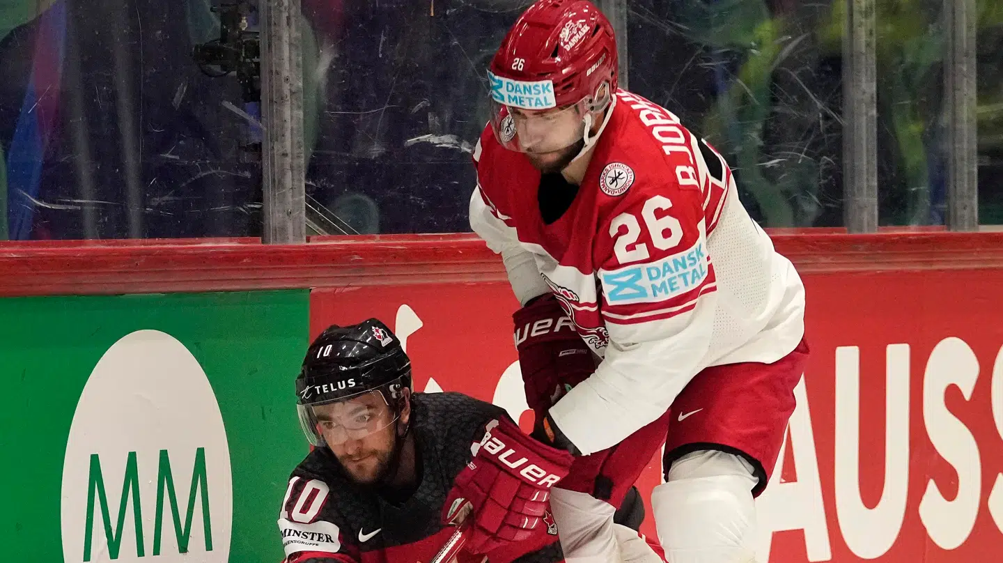 Patrick Bjorkstrand i rødhvid trøje i kamp om pucken med Canadas Nicolas Roy i VM i Helsinki i 2022. Danmark vandt sensationelt over de forsvarende verdensmestre med 3-2, første sejr over Canada.