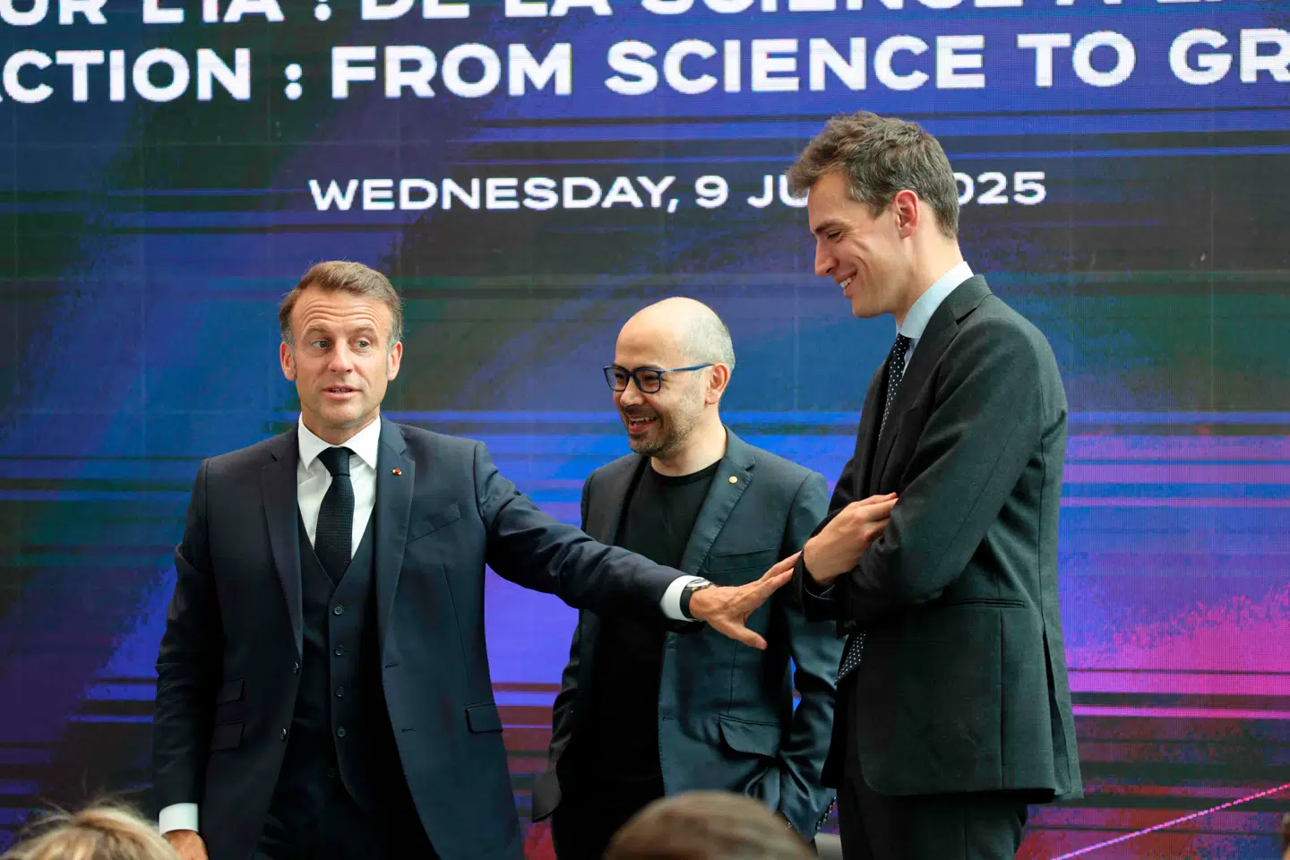 Frankrigs præsident, Emmanuel Macron, (til venstre) på scenen ved et arrangement i London om kunstig intelligens i juli 2025 sammen med topchefen for franske Mistral, Arthur Mensch (til højre), og topchef Demis Hassabis (i midten) fra Googles DeepMind Technologies.