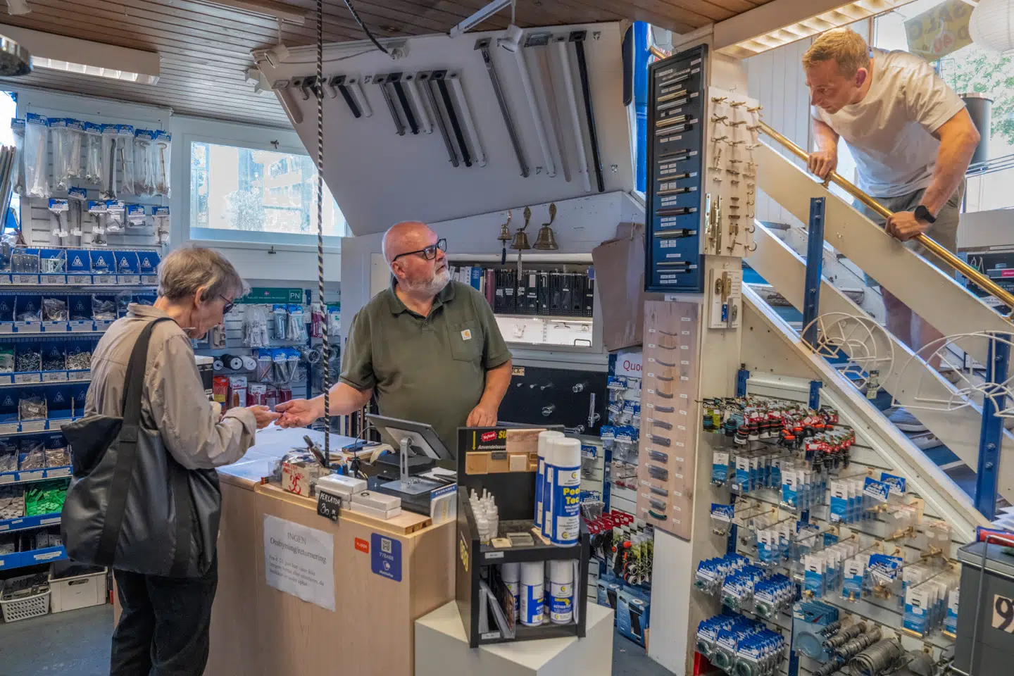 Direktør Jan Pedersen (bag kassen) skal igen ekspedere kunder, når butikken genåbner i nye lokaler.
