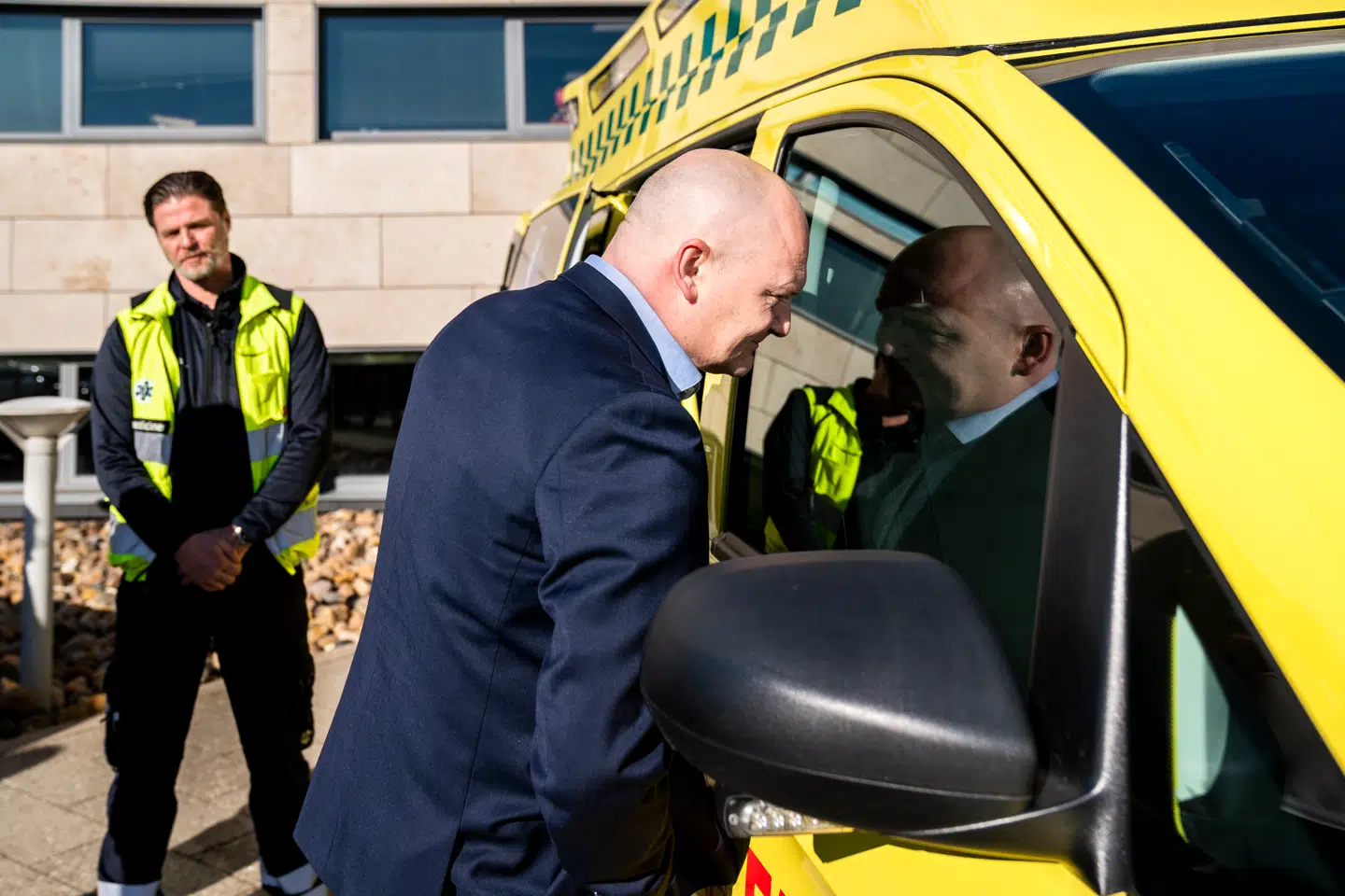 »Hvis vi pludselig får en ekstra opgave med at skulle ringe til lægen, eller vi bliver ramt af en skade, når vi falder eller mister grebet om hækkesaksen, så mister vi – eller i hvert fald nogle af os – evnen til at vise samfundssind og tage hensyn til andre,« skriver blandt andre regionsrådsformand i Hovedstaden Lars Gaardhøj (S). Her inspicerer Gaardhøj, i forgrunden, Danmarks første el-ambulance. Arkivfoto: Ida Marie Odgaard/Ritzau Scanpix