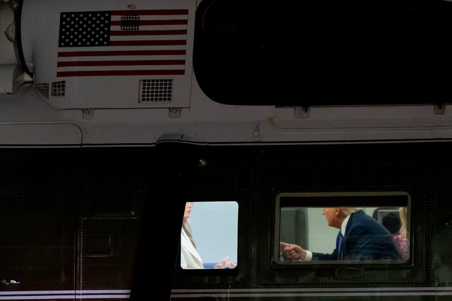 Melania Trump og Donald Trump i samtale ombord på Marine One. Her ses præsidenten pege på sin hustru.