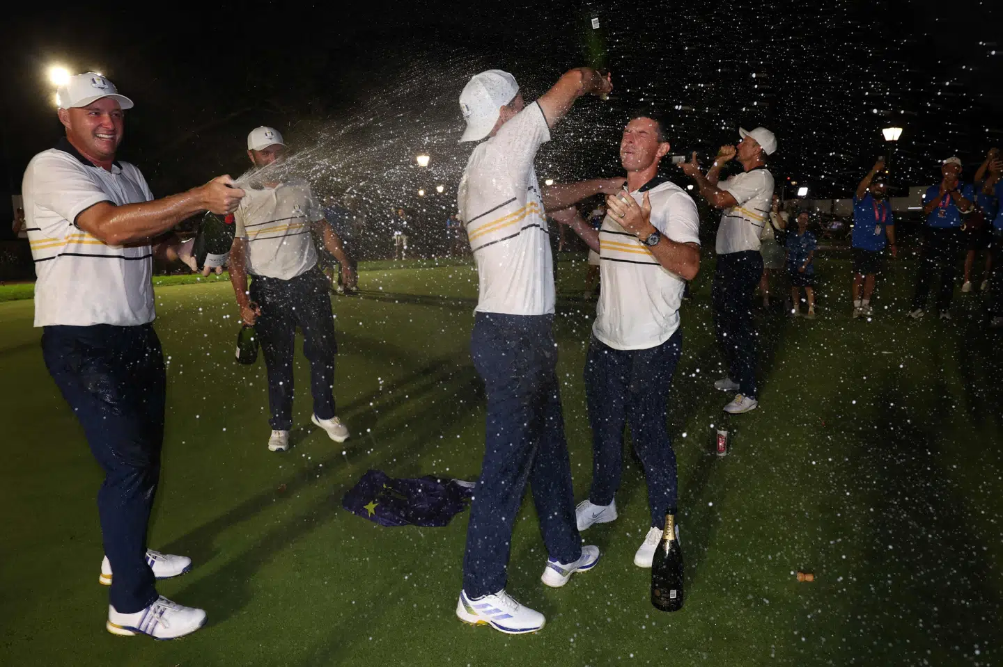 Rasmus Højgaard giver her holdkammerat Rory McIlroy et champagnebad efter sejren i Ryder Cup.