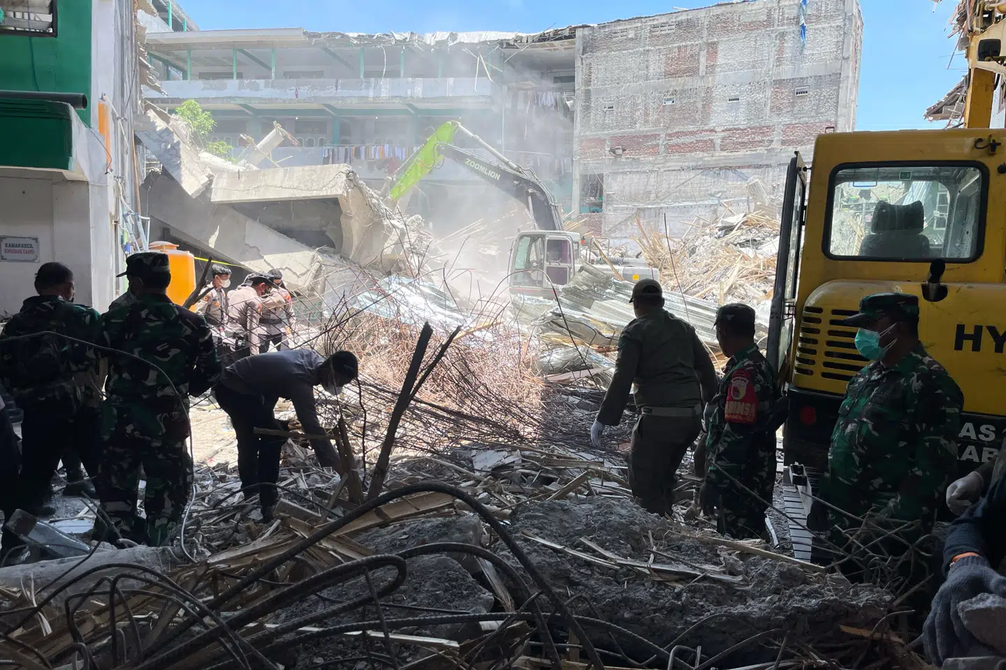Billede fra lørdag af redningsarbejdere, der undersøger område ved kollapset bygning i Sidoarjo i Østjava i Indonesien.