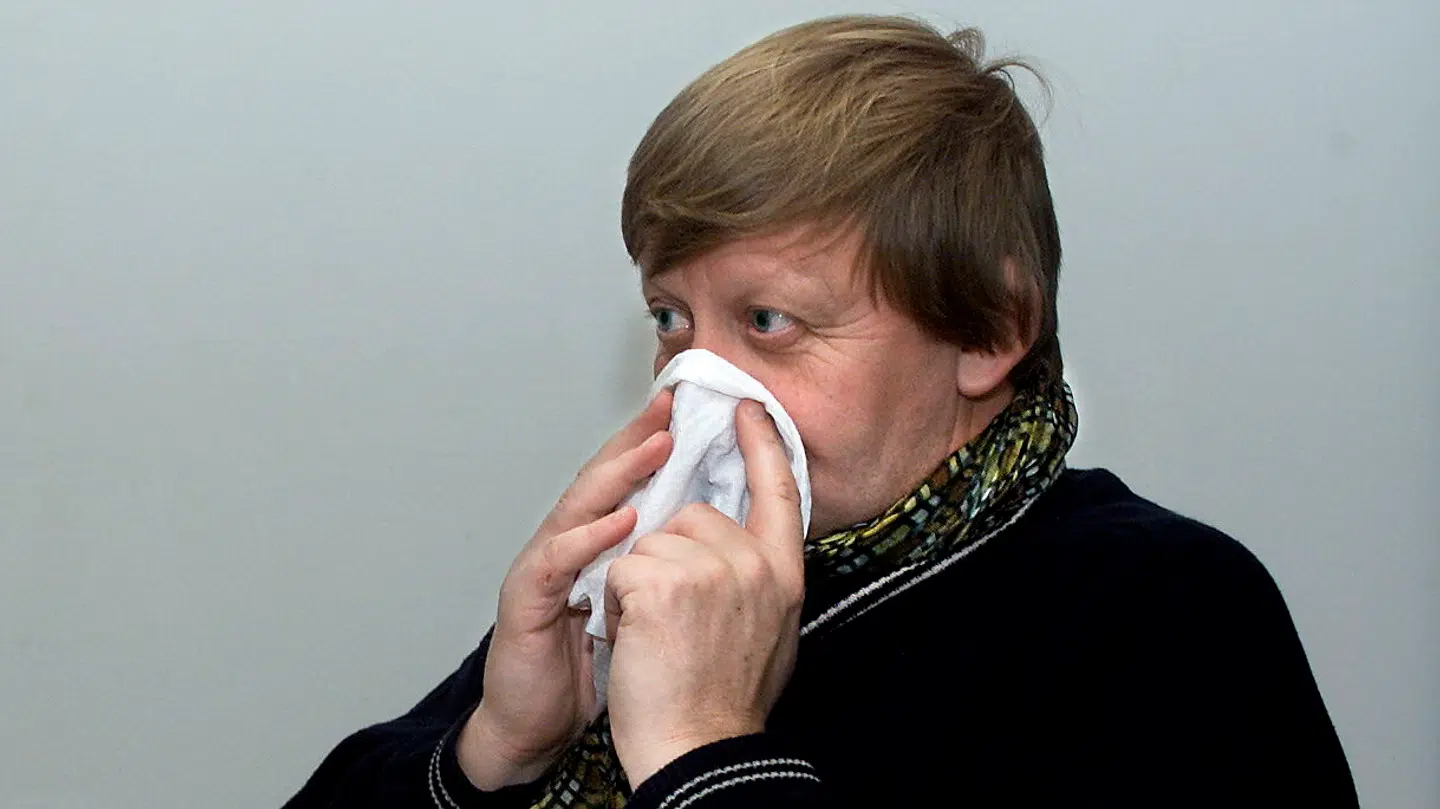 En forkølet mand nyser.