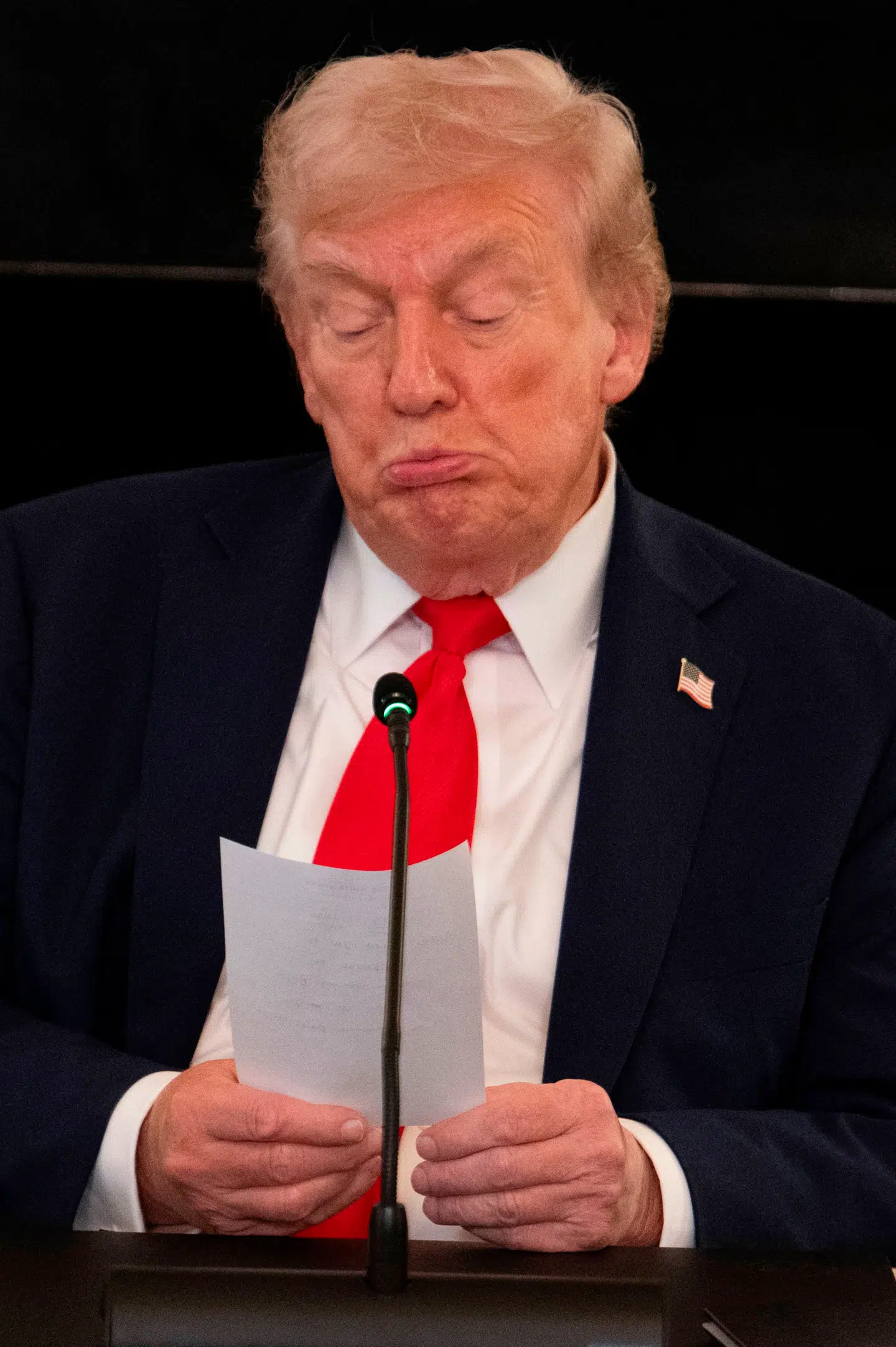 Donald Trump læser sedlen.