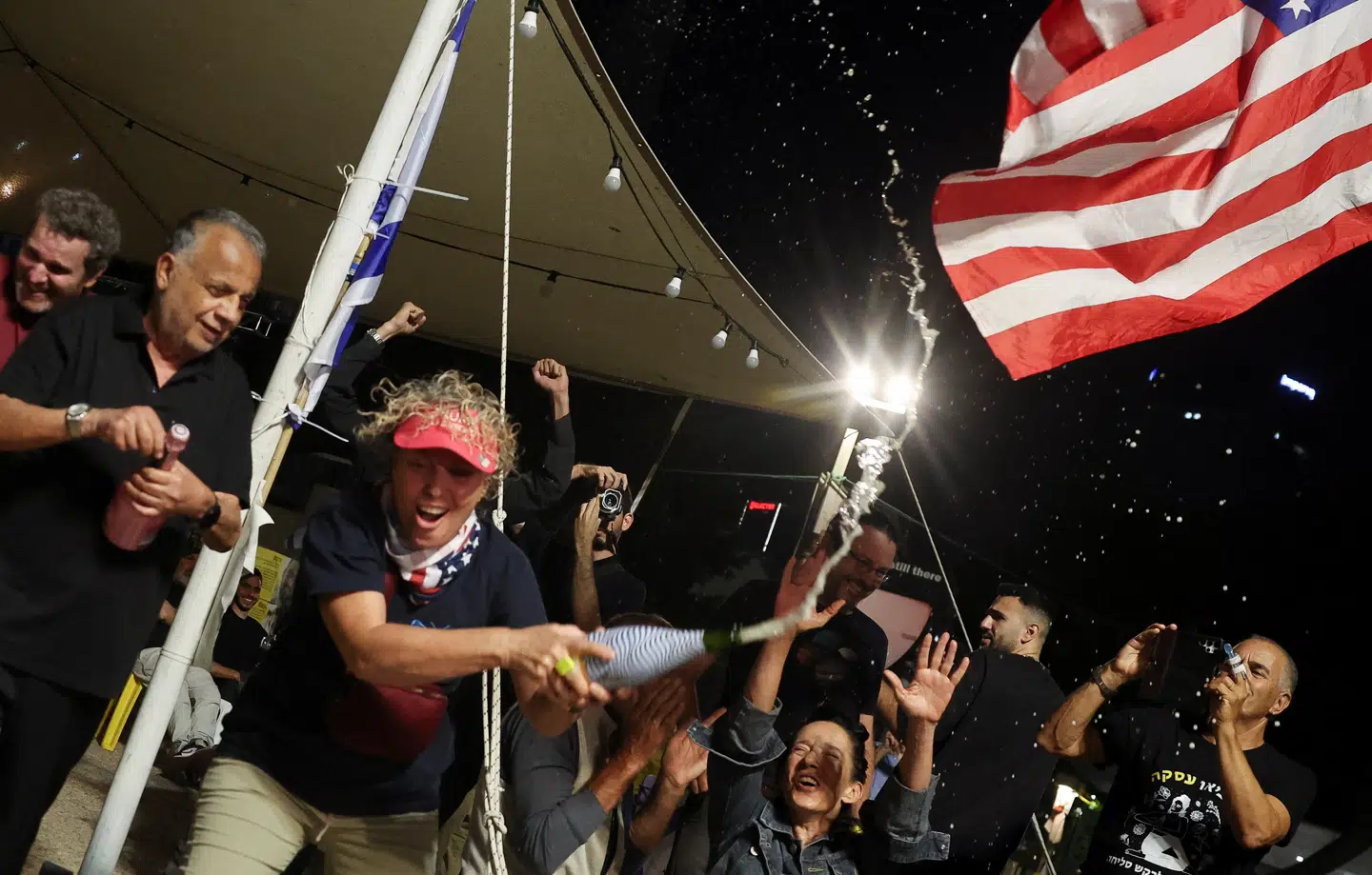 Demonstranter på »Gidselpladsen« i Tel Aviv lader champagnepropperne flyve efter Trumps udmelding om at Hamas og Israel er blevet enige om at udvekse gidlserne for palæstinensiske fanger.