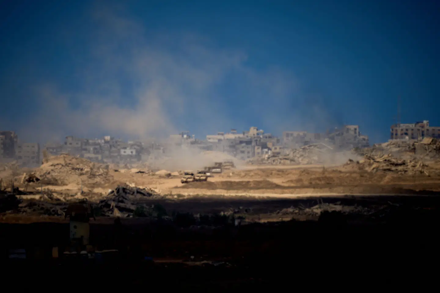 Israelske kampvogne kører ud af Gaza mod grænsen til Israel fredag. Billedet er taget fra det sydlige Israel.