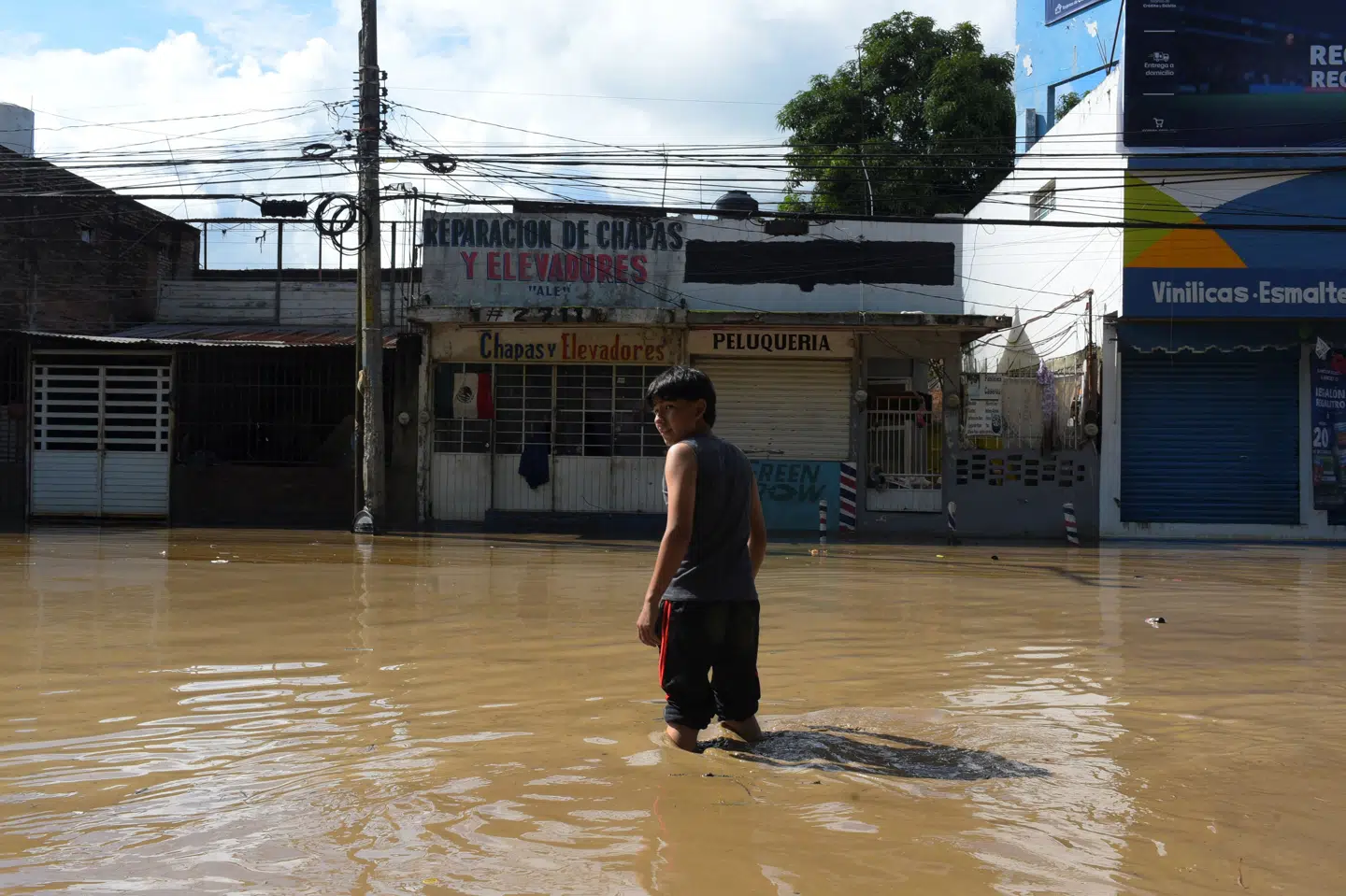 En person går igennem en oversvømmet gade i Poza Rica i den mexicanske delstat Veracruz efter voldsom regn.