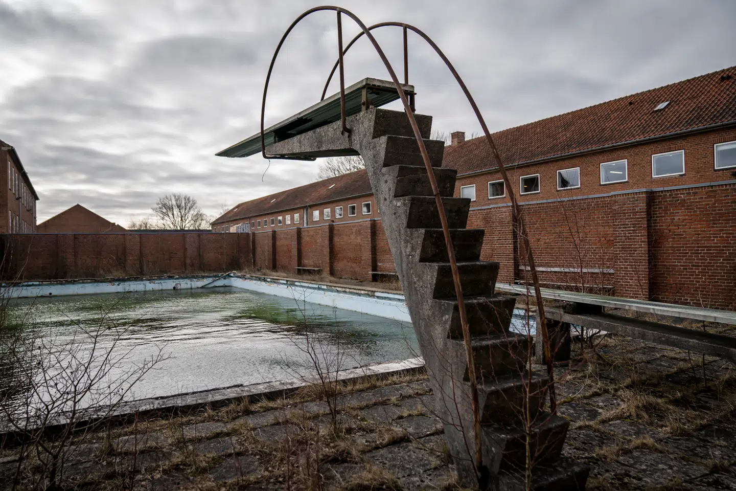 Billedet af det misligholdte svømmebassin, som engang blev doneret til Livgarden i Høvelte, blev symbolet for nedslidningen. I begyndelsen af oktober – to et halvt år senere – begyndte nedrivningen.